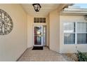 Front entry with glass door and decorative iron wall art at 334 Caloosa Palms Ct, Sun City Center, FL 33573