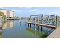 Scenic boat dock featuring lifts and views of the marina and residential buildings on a sunny day at 399 150Th Ave # A203, Madeira Beach, FL 33708