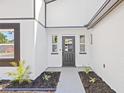 Modern front entry with dark gray door and gray paver walkway at 2151 Orangeside Rd, Palm Harbor, FL 34683