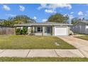 Single story home with gray exterior, landscaped lawn, and attached garage at 2219 13Th Sw Ave, Largo, FL 33770