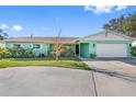 Front view of a light green ranch style home with a large driveway at 6348 29Th N Ave, St Petersburg, FL 33710