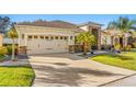 Two-car garage with light beige doors and stone facade at 10431 Machrihanish Cir, San Antonio, FL 33576