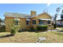 Yellow house with a green roof, awnings, and a yard at 1360 Prescott S St, St Petersburg, FL 33712