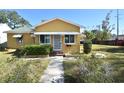 Yellow house with a green roof, awnings, and a yard at 1360 Prescott S St, St Petersburg, FL 33712