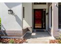 Close-up of the front door featuring a striking red screen door and modern lighting fixtures for curb appeal at 1808 Cypress Trace Dr # 1808, Safety Harbor, FL 34695