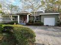 House with green exterior, red front door, and attached garage at 4722 Trade Winds S Dr, Gulfport, FL 33711