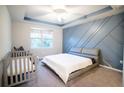 Bright bedroom with a king-size bed and modern gray accent wall at 7465 Yale Harbor Dr, Wesley Chapel, FL 33545