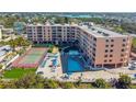 Aerial view showing building, pool, and tennis court at 1000 Gulf Blvd # 302, Indian Rocks Beach, FL 33785