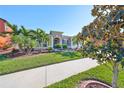 Landscaped lawn, sidewalk, and charming house exterior at 13230 Fawn Lily Dr, Riverview, FL 33579