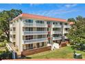 Condo building showcasing multiple balconies, brick detailing, and well-maintained landscaping at 2650 Pearce Dr # 403, Clearwater, FL 33764