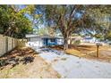 Newly renovated light blue house with a well-manicured front yard and a long driveway at 6713 Pomander Ave, New Port Richey, FL 34653