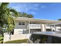 Condominium building exterior with parking and tropical plants at 930 Virginia St # 201, Dunedin, FL 34698