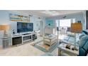 Bright living room with light blue walls, comfy furniture, and balcony access at 10216 Regal Dr # 603, Largo, FL 33774