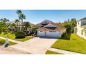 Two-story house with a three-car garage and lush green grass at 10511 Martinique Isle Dr, Tampa, FL 33647