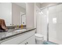 Bathroom with granite countertop, shower, and toilet at 2101 Sunset Wind Loop, Oldsmar, FL 34677