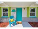 Welcoming front porch with teal chair and jellyfish decor at 4021 Eagle Nest Dr, Hernando Beach, FL 34607