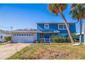 Two-story house, blue exterior, white garage door, and palm trees at 4126 13Th Ne Ln, St Petersburg, FL 33703