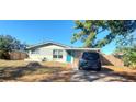 Ranch style home with teal front door and car parked on driveway at 7045 Lenox Dr, New Port Richey, FL 34653