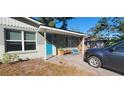 Front door view of a renovated home with teal door and porch at 7045 Lenox Dr, New Port Richey, FL 34653