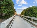 White boardwalk leads to sandy beach at sunset at 843 Eldorado Ave, Clearwater Beach, FL 33767