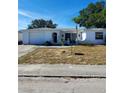 Ranch-style home with a single-car garage and mature landscaping at 1147 Viking Dr, Holiday, FL 34691