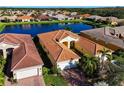 Aerial view of a community with houses near a lake at 4845 Marble Springs Cir, Wimauma, FL 33598