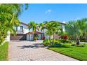 Home exterior showcasing a Mediterranean style with palm trees and a paved driveway at 747 Brightwaters Ne Blvd, St Petersburg, FL 33704