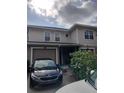 Front view of a two-story townhome with a black car parked in the driveway at 8003 Bally Money Rd, Tampa, FL 33610