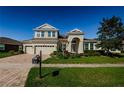 Two-story house with a three-car garage and manicured lawn at 8319 Swiss Chard Cir, Land O Lakes, FL 34637