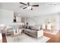 Virtually staged living room with L-shaped sofa, dining area, and hardwood floors at 10817 Great Carlisle Ct, Riverview, FL 33578