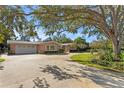 Pink single story home with circular driveway, mature trees, and lush landscaping at 1131 Snell Isle Ne Blvd, St Petersburg, FL 33704