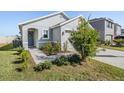 Exterior view of a charming one-story house with landscaping and a two-car garage at 16838 Delia St, Wimauma, FL 33598