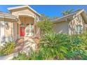 Welcoming front entry with red door and lush landscaping at 3125 Bent Creek Dr, Valrico, FL 33596