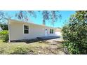 A charming home exterior showcasing a well-maintained lawn, new windows, and a quaint front porch entrance at 3562 Fisher Rd, Palm Harbor, FL 34683