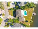 Birds-eye view of a home with a pristine pool and patio, surrounded by tropical landscaping near a waterfront at 5108 W San Jose St, Tampa, FL 33629