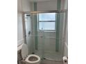 Bathroom featuring a glass-enclosed shower with tile and a matching toilet at 10170 64Th Ave, Seminole, FL 33772