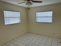 Cozy bedroom featuring neutral walls, tile flooring, and two large windows with blinds at 10170 64Th Ave, Seminole, FL 33772
