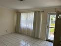 Bright living room with tile floors, sheer curtains and a glass front door at 10170 64Th Ave, Seminole, FL 33772