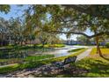 Community features a pond, walking path, and bench under a large tree at 10396 Carrollwood Ln # 27, Tampa, FL 33618