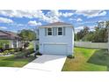 Two-story house with light blue exterior, two-car garage, and small yard at 5018 Bella Armonia Cir, Wimauma, FL 33598