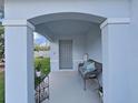 Covered front porch with seating and small garden at 5018 Bella Armonia Cir, Wimauma, FL 33598