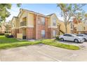 Two-story condo building with brick and siding, parking, and green space at 8722 Mallard Reserve Dr # 204, Tampa, FL 33614