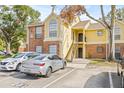 Condo building with brick and yellow siding, stairs, and parking at 8722 Mallard Reserve Dr # 204, Tampa, FL 33614