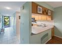 Kitchen with light cabinets, double sink, and breakfast bar at 9433 Harbor Greens Way # 403, Seminole, FL 33776
