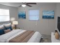 Virtually staged bedroom with a bed, nightstand, and ocean-themed artwork at 1030 Landau St, Holiday, FL 34690