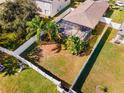 Aerial view of backyard with screened enclosure, fenced yard, and palm trees at 12610 Saulston Pl, Hudson, FL 34669