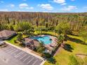 Community pool with clubhouse and surrounding landscape at 12610 Saulston Pl, Hudson, FL 34669