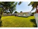 Spacious backyard featuring a well-maintained lawn and a patio area with a grill, perfect for outdoor entertaining at 4510 Helena Ne St, St Petersburg, FL 33703