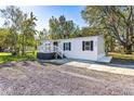 White manufactured home with gray accents and a spacious yard at 6633 Dog Rose Dr, Wesley Chapel, FL 33544