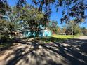 Light blue house with a large yard and mature trees, situated on a quiet street at 6928 E 29Th Ave, Tampa, FL 33619